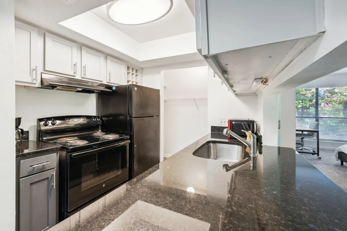 A modern kitchen view emphasizing black appliances, a spacious kitchen island, and granite surfaces. The layout invites both culinary creativity and entertaining, making it perfect for hosting dinner parties or casual gatherings.